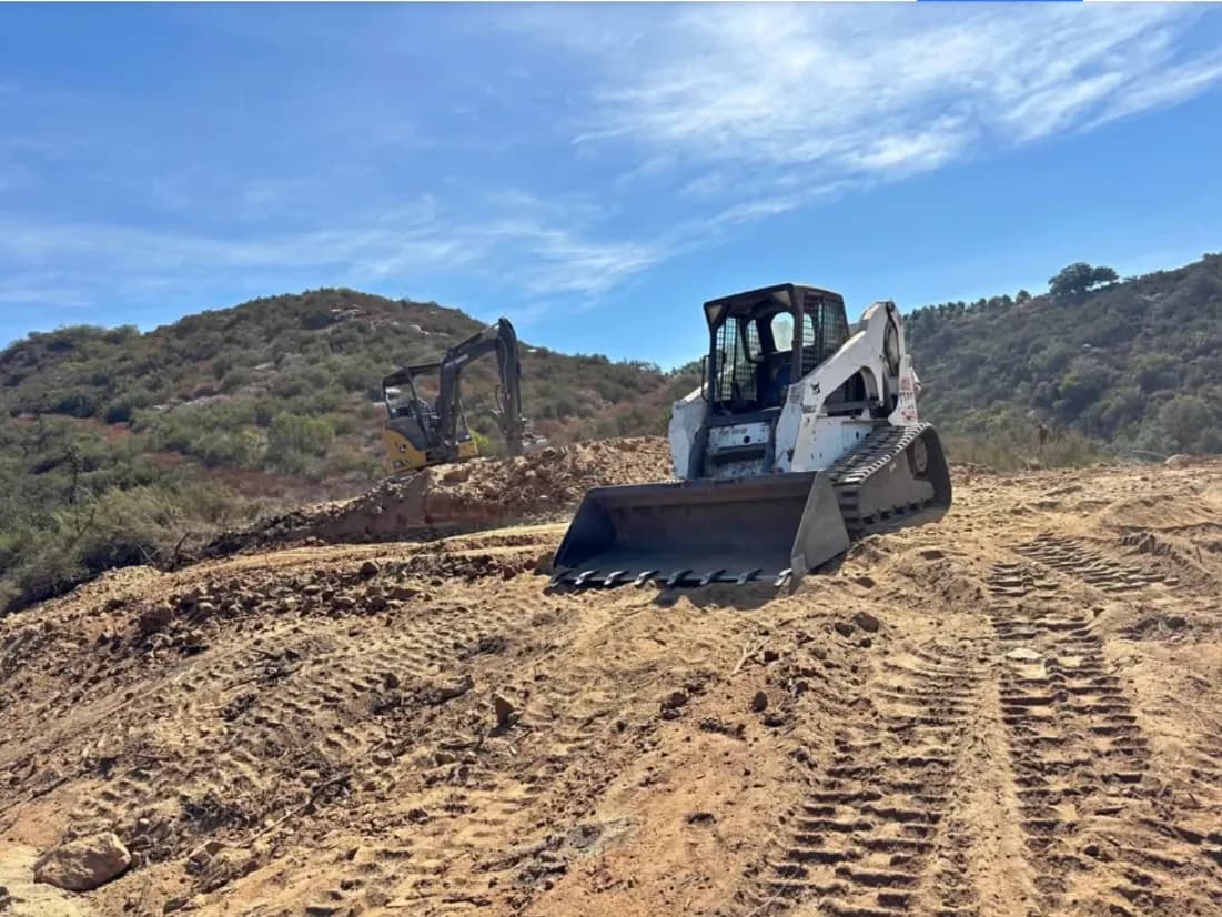 Bobcat T300 and mini excavator grading a hillside lot in Fallbrook, California